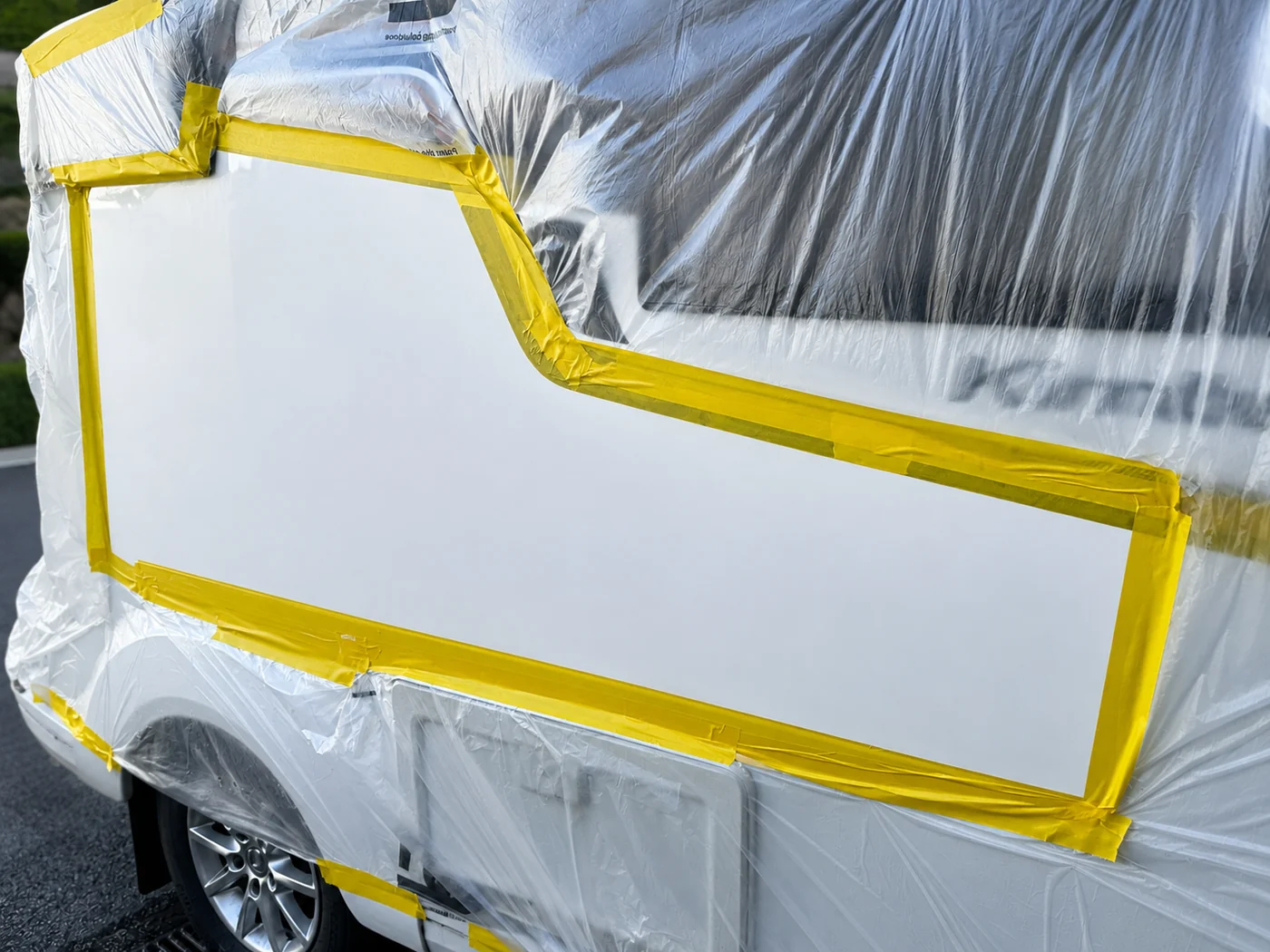 Caravan body panel carefully masked for a controlled local refinishing repair